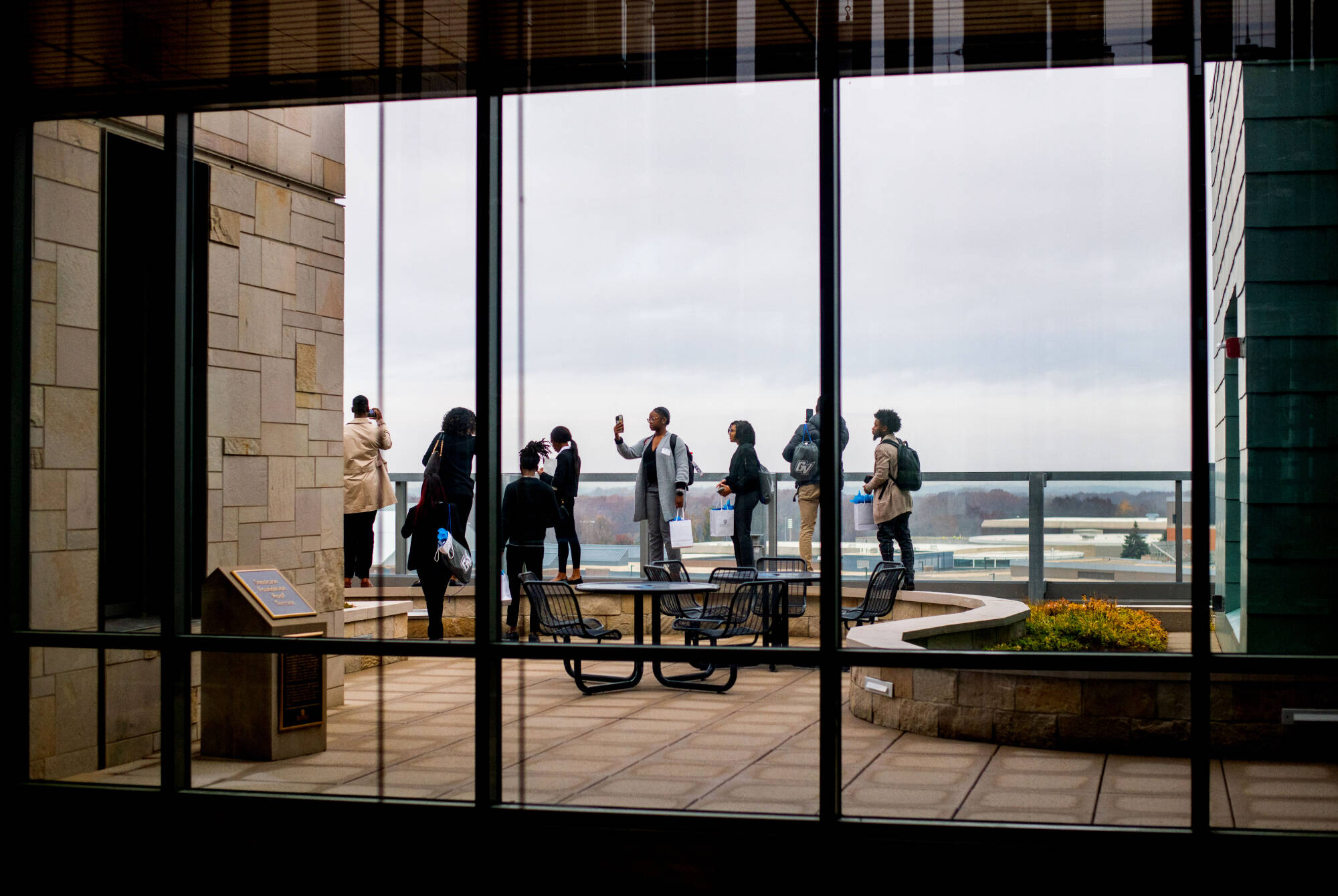 Students from four HBCUs take photos from the fourth floor rooftop garden of the Mary Idema Pew Library while touring GVSU Oct. 31.